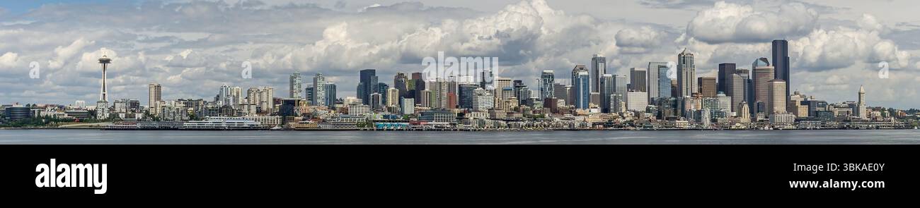Die gesamte Skyline von Seattle, Washington, von der anderen Seite des Puget Sound an einem bewölkten Tag aus gesehen, mit der Space Needle und modernen Wolkenkratzern. Stockfoto