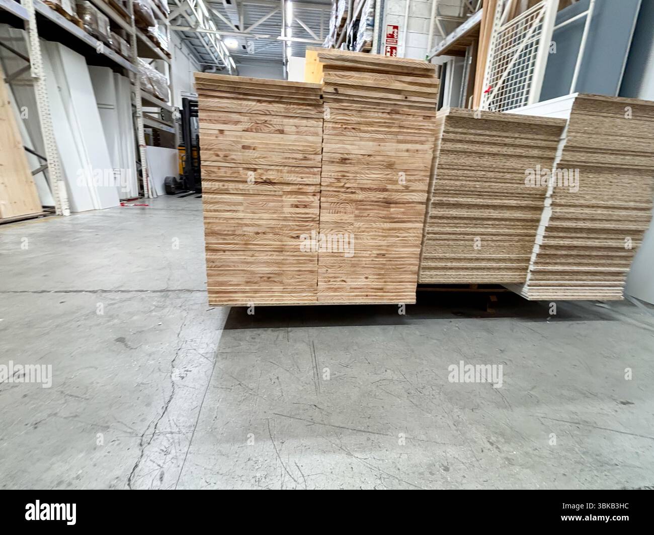 Alicante, Spanien - 18. Juni 2025: In einem geräumigen Lager mit Industrieregeln und Betonböden werden stapelbare Holzbretter ausgestellt Stockfoto
