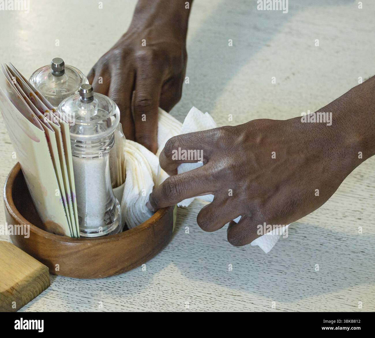 Der Kellner legt Servietten auf den Tisch, in einem Café Stockfoto