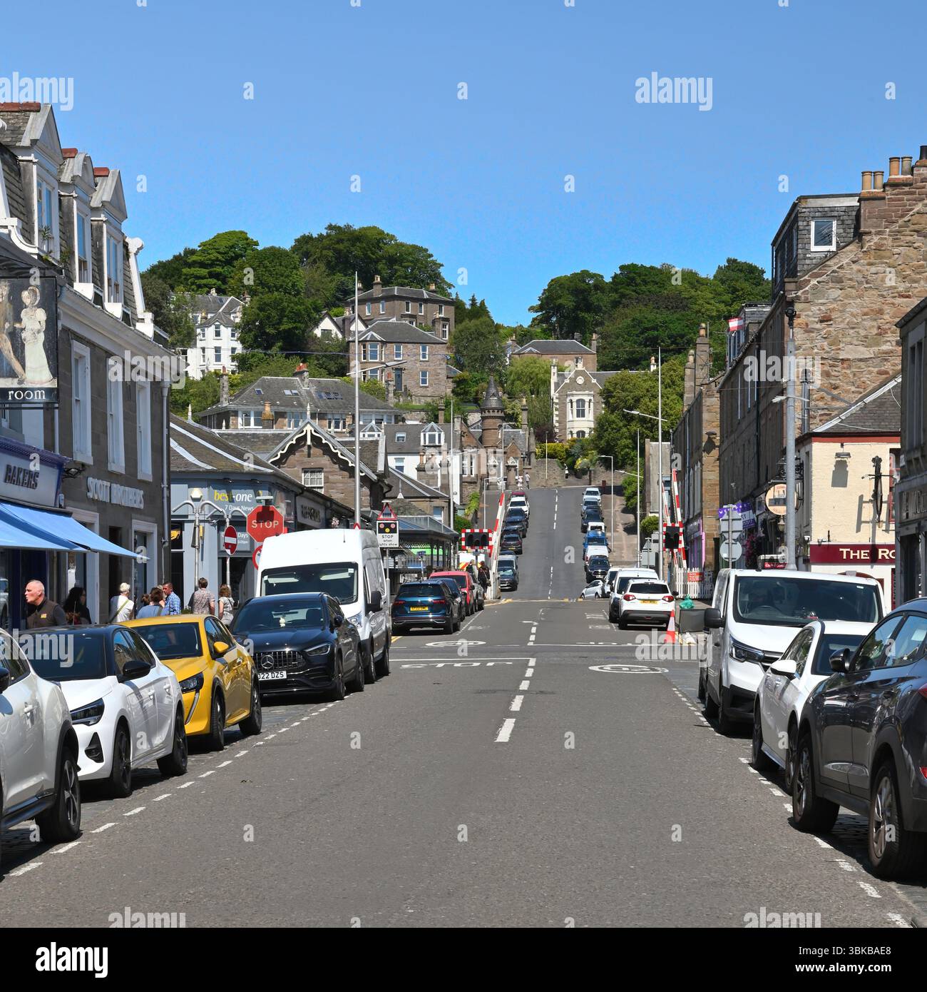 Unabhängige Geschäfte, geparkte Autos und Häuser an der Gray Street in Broughty Ferry an der Ostküste Schottlands an einem sonnigen Juni. Stockfoto