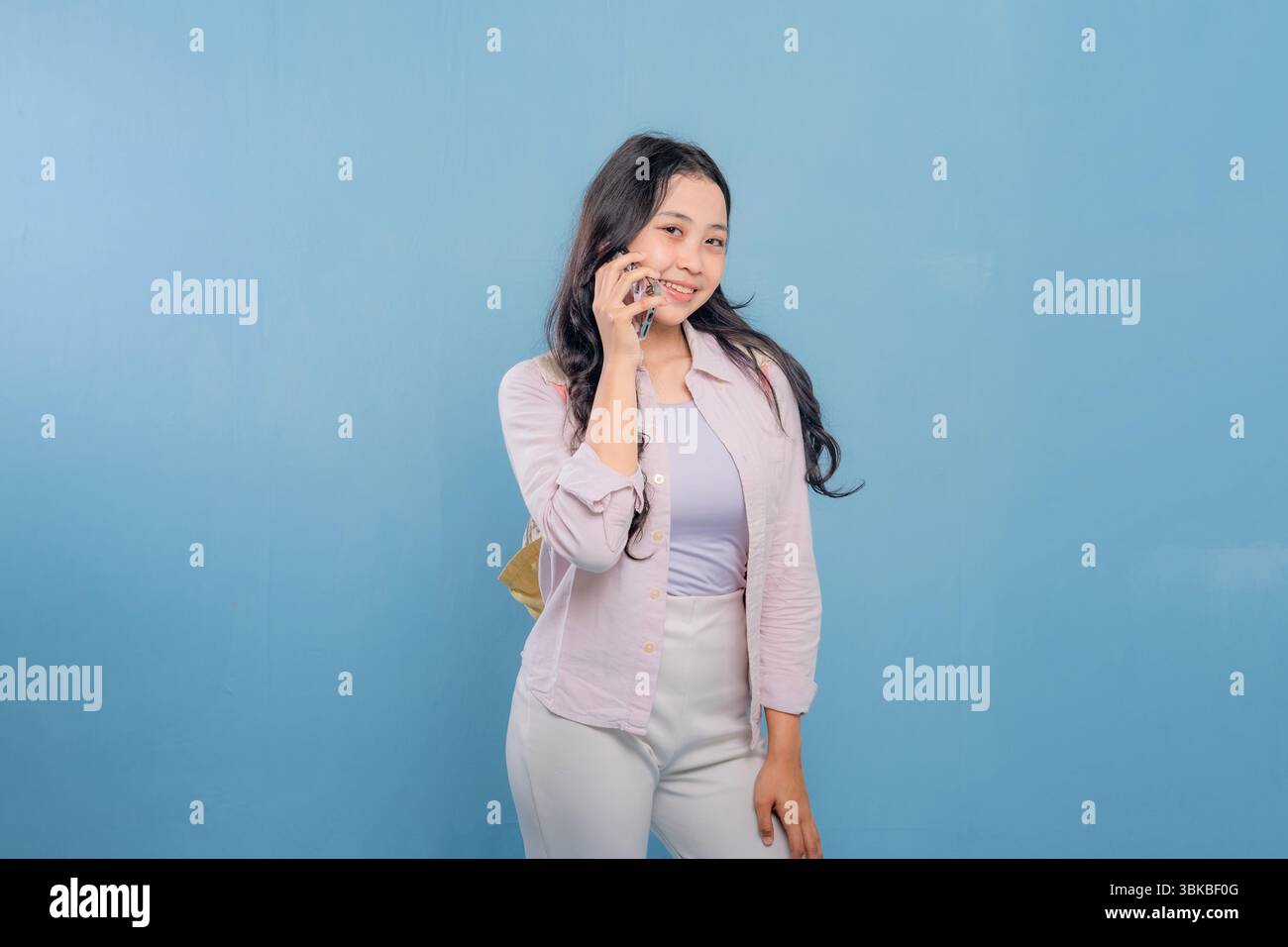 Eine Frau redet auf ihrem Handy. Sie lächelt und ist gut gelaunt Stockfoto