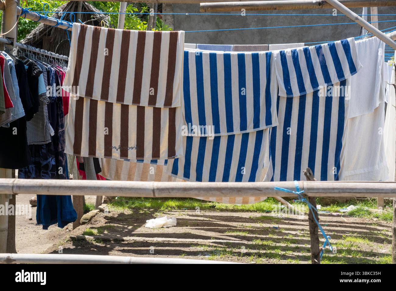 Gili, Lombok, Indonesien - 7. Januar 2025: Kleidung hängt an einer Wäscheleine. Die Kleidung ist gestreift und trocknet in der Sonne Stockfoto