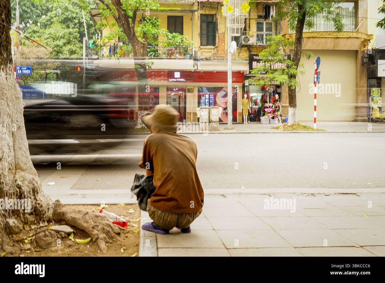 Mann sitzt auf der Straße, Hanoi Stockfoto