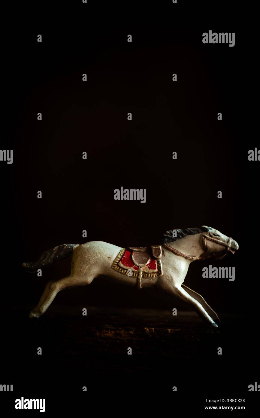 Ein Vintage-Spielzeugpferd zeigt eine galoppierende Haltung und betont die komplizierte Handwerkskunst seines Sattels und seiner Mähne. Stockfoto