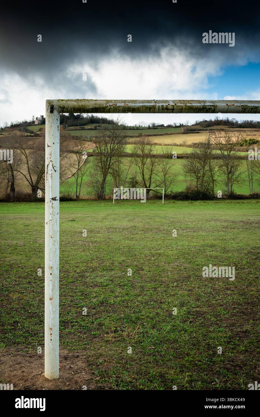 Ein alter und verwitterter Fußballtor steht leer auf einem grünen Feld, umgeben von einer friedlichen ländlichen Landschaft. Auvergne. Frankreich Stockfoto