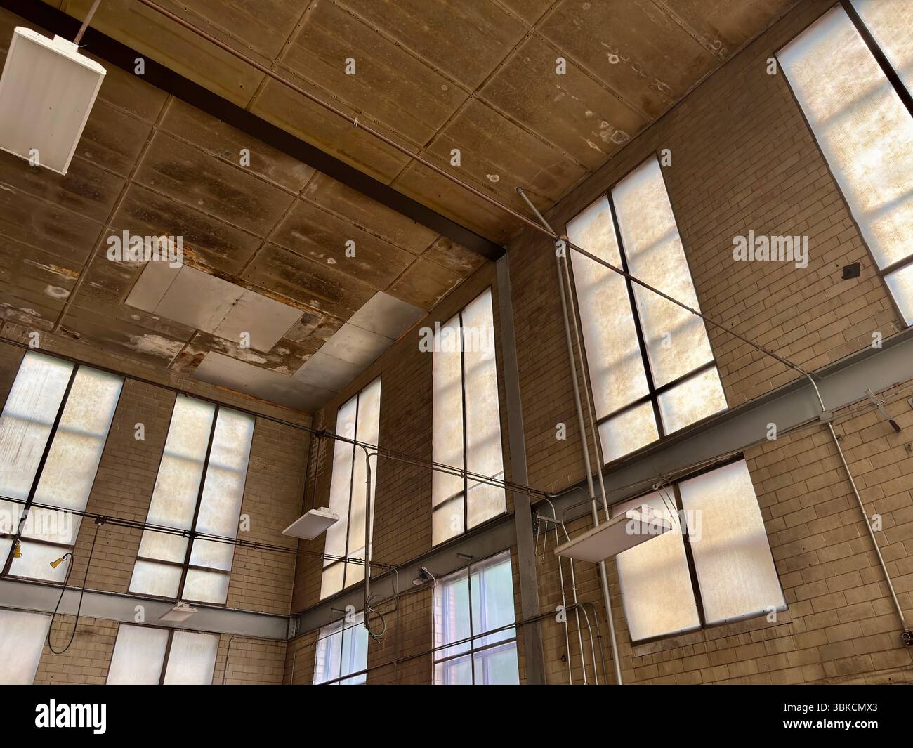 Verlassene Fabrik mit natürlichem Licht von hohen Fenstern Stockfoto
