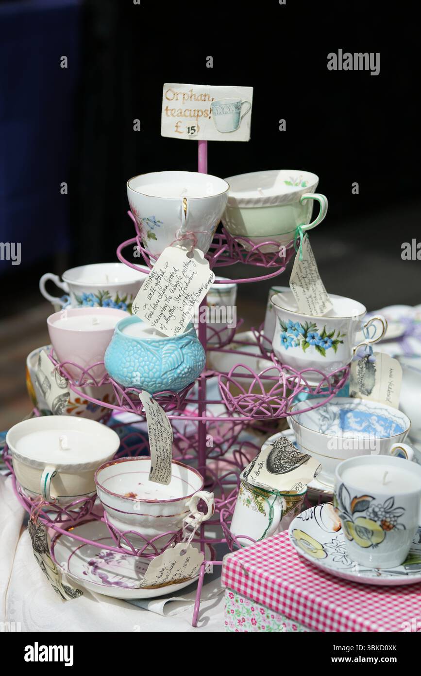 Farbenfrohe Vintage-Teetassen auf einem mehrstufigen Stand auf einem Markt. Greenwich, London, England Stockfoto