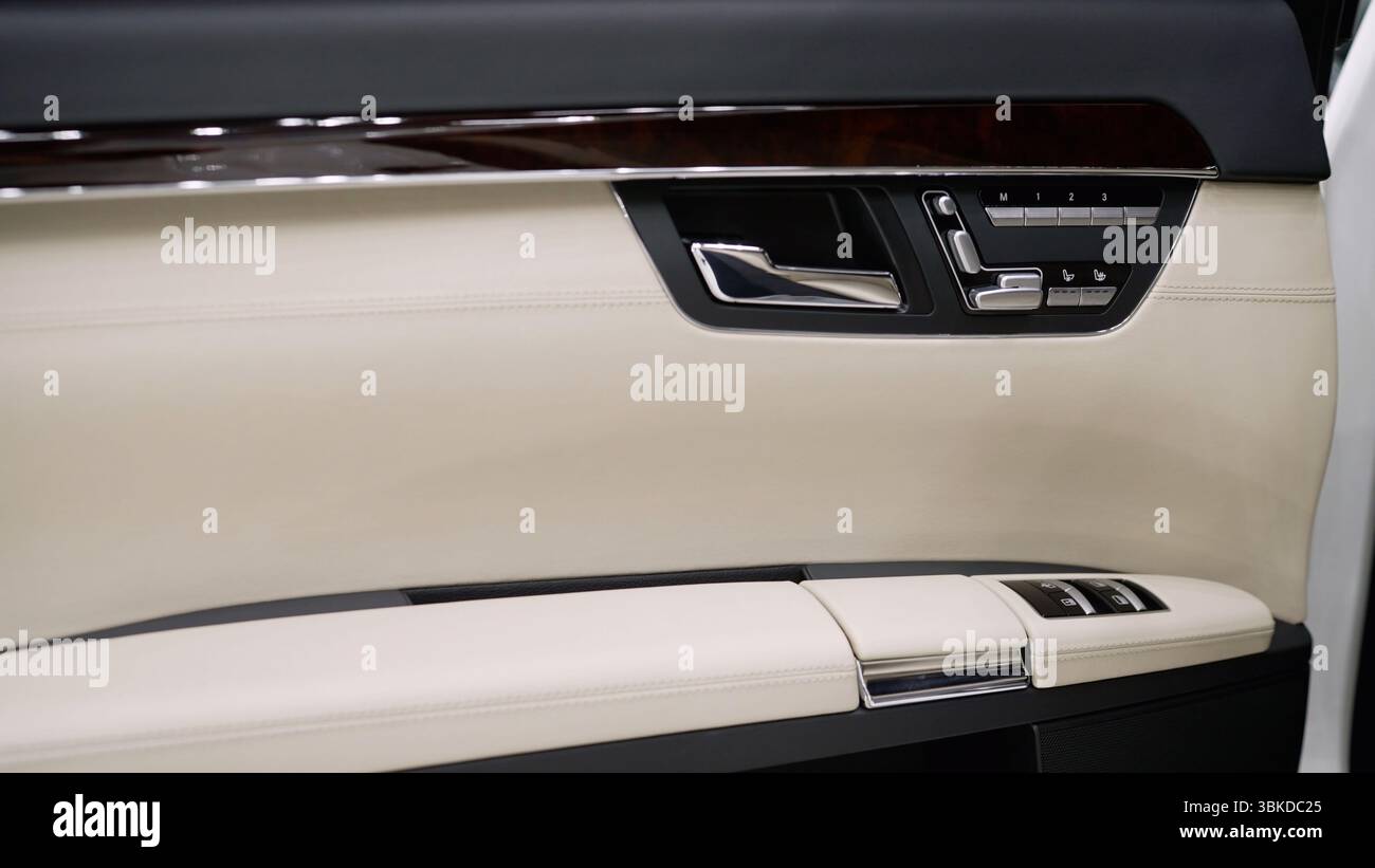Tür von innen in weißem Leder, ein teures ausländisches Auto. Innenraum der Autotür. Autotür von innen. Innenraum des Fahrzeugs. Stockfoto