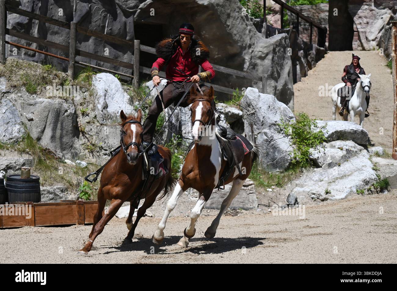 Bad Segeberg, Deutschland. Juni 2025. Ein Stuntman als Kutsche reitet bei einer Presseveranstaltung im Freilichttheater am Kalkberg in Bad Segeberg zwei Pferde gleichzeitig. In seiner 72. Spielzeit präsentiert das Karl-May-Festival mit dem Stück „Half-Blood“ Drama, Intrigen und Romantik zwischen Westlern und Comanchen. Die Saison läuft vom 28. Juni bis zum 7. September 2025. Quelle: David Hammersen/dpa/Alamy Live News Stockfoto