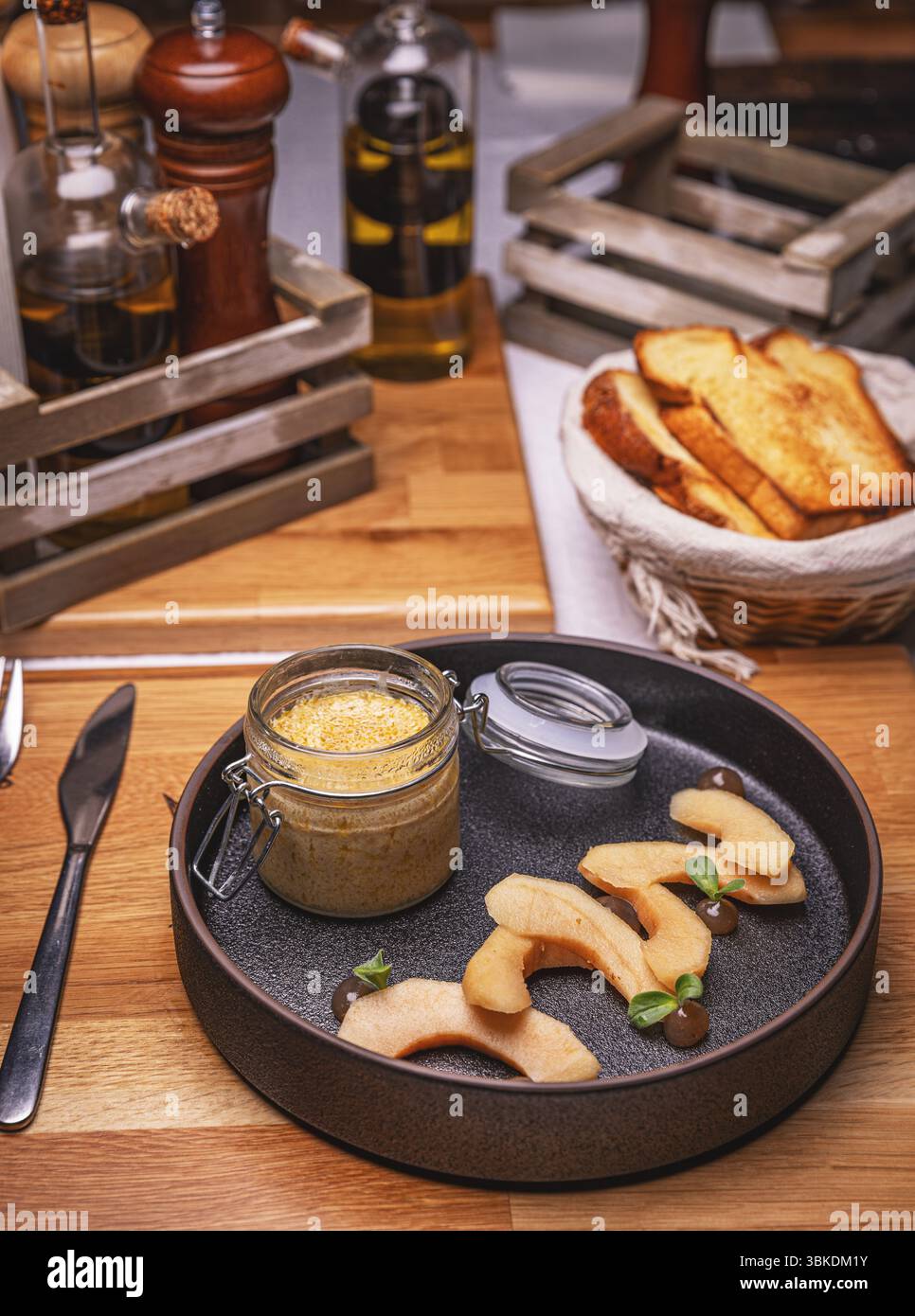 Hühnerleberpastete mit karamelisierter Quitte und geröstetem Brot auf dem Restauranttisch Stockfoto