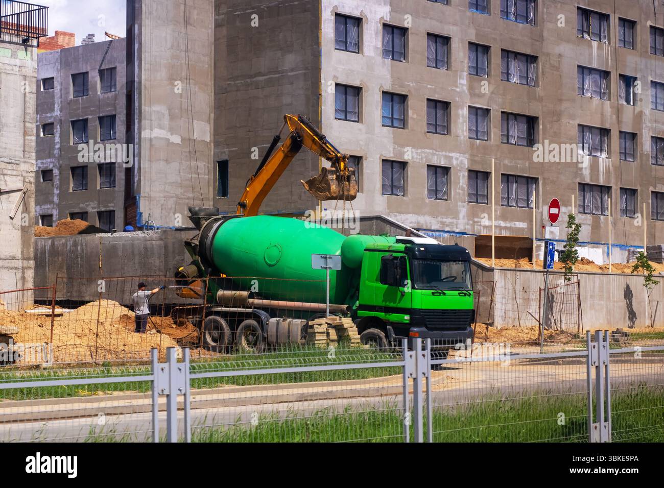 Derzeit wird auf einer Baustelle ein großer Betonmischer mit frischem Beton beladen, um laufende Bauprojekte zu erleichtern Stockfoto