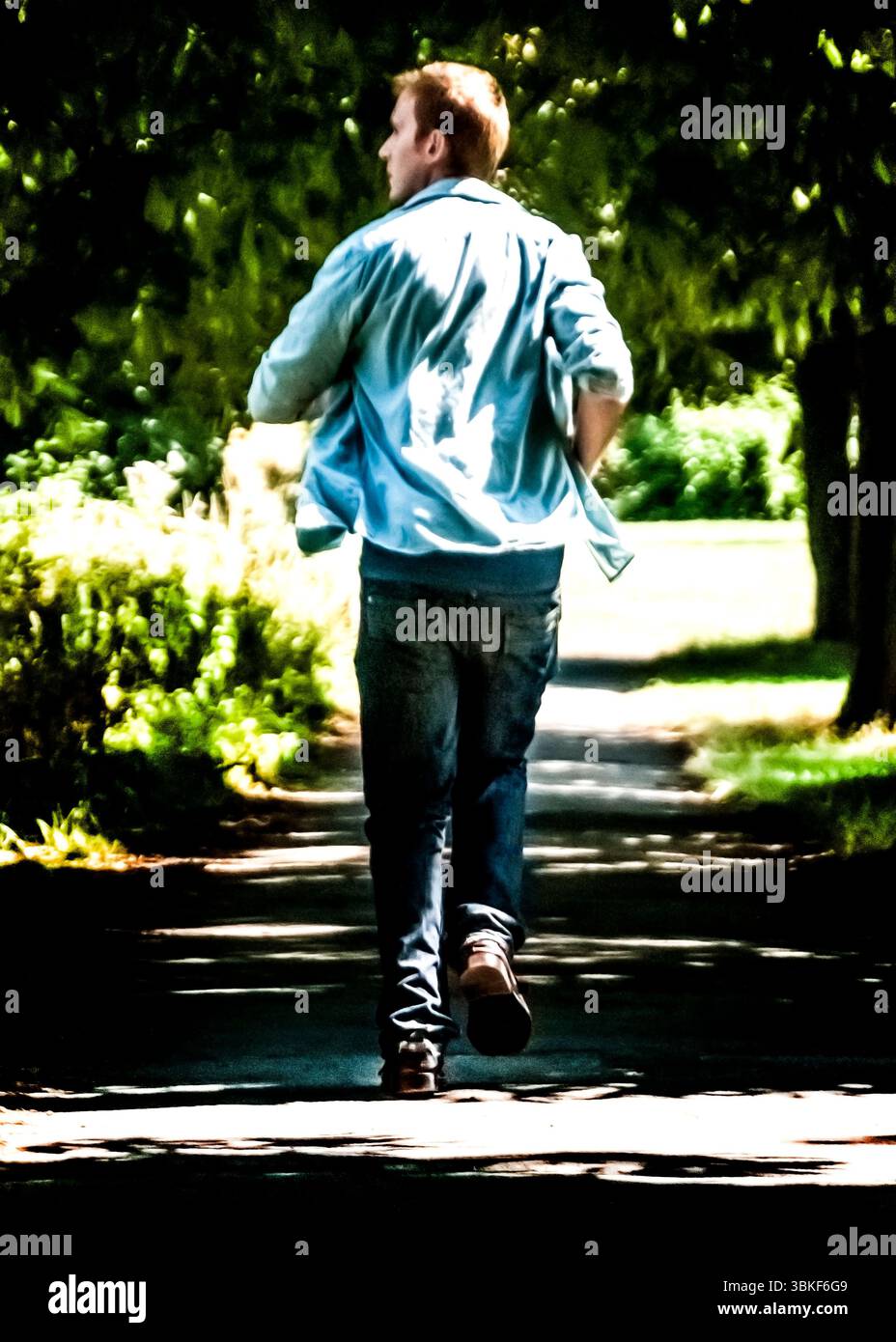 Eine Person, die auf einem Weg in einem Park läuft. Stockfoto