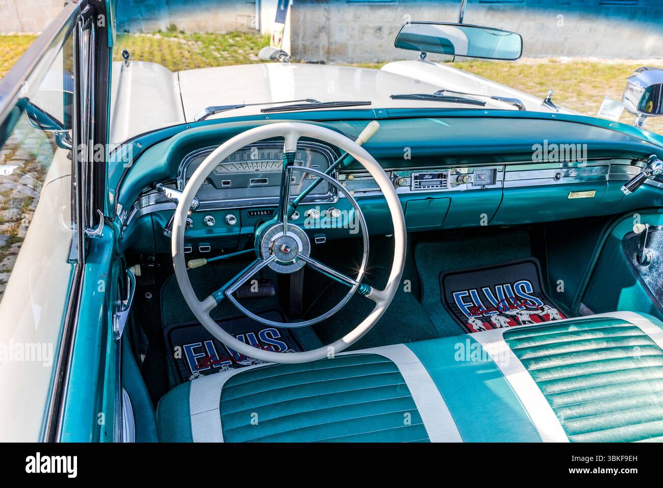 Das Interieur eines restaurierten amerikanischen Cabrios aus den späten 1950er Jahren mit türkisfarbenen und weißen Polstern, dem originalen Armaturenbrett und einem elfenbeinfarbenen Lenkrad. Die maßgeschneiderten Fußmatten und Sitzbezüge tragen das Wort „Elvis“. Der Wagen war Teil eines Oldtimer-Treffens auf dem Gelände der Corderie Royale am Quai Joseph Bellot in Rochefort. Quai Joseph Bellot, Rochefort, Charente-Maritime, Nouvelle-Aquitaine, Frankreich Stockfoto