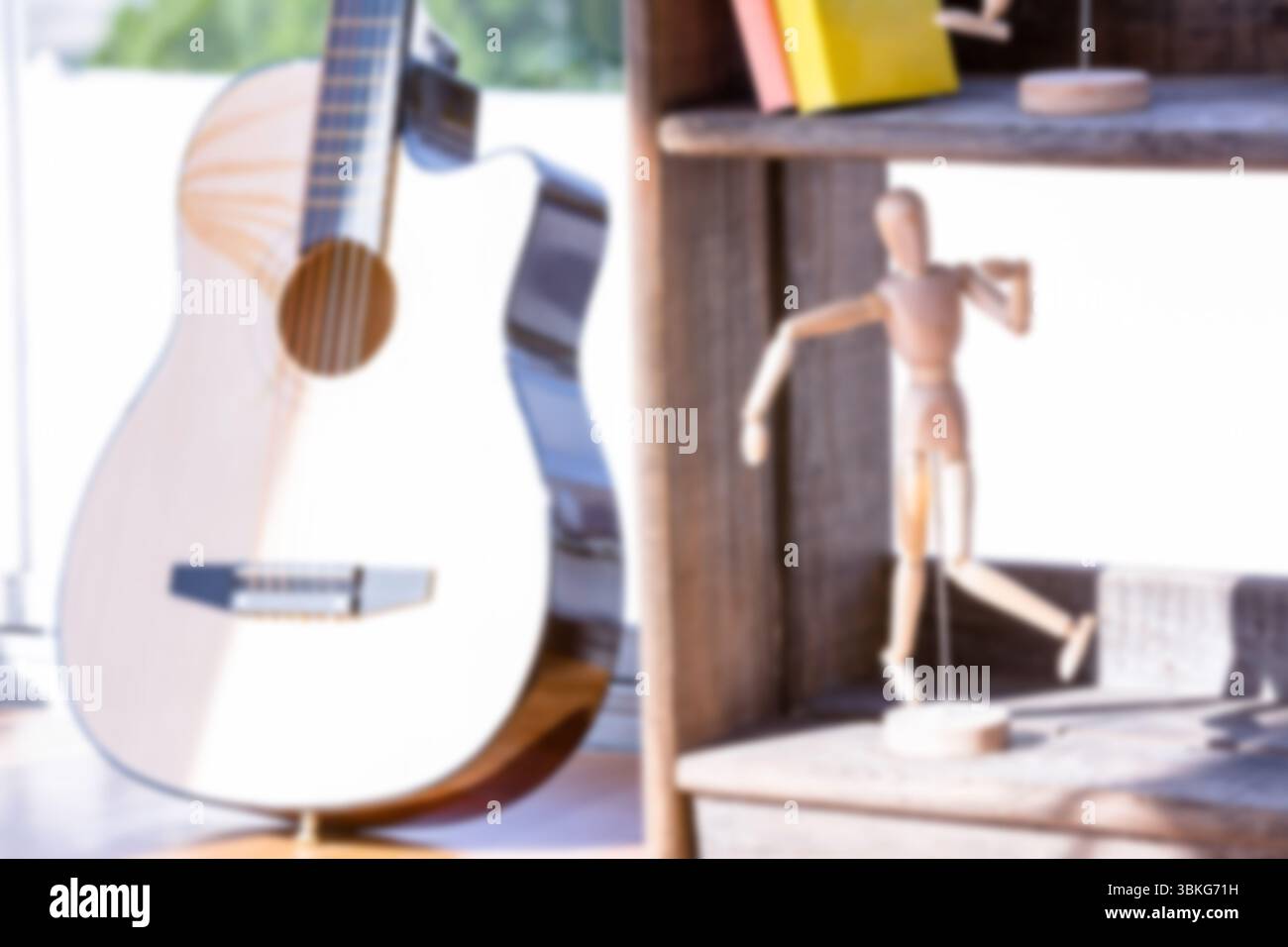 Figur auf Regal an der Gitarre in der Nähe des Fensters Stockfoto