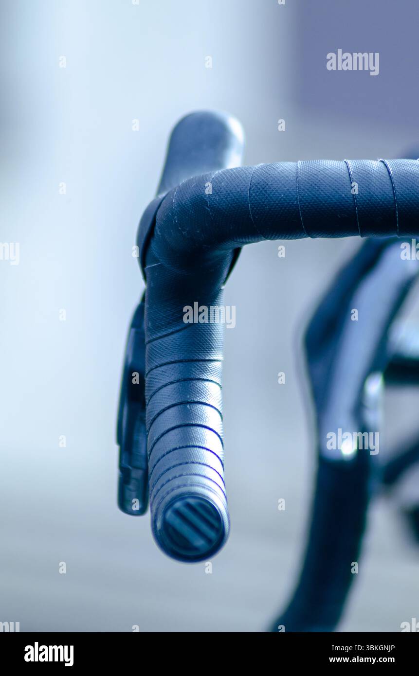 Fahrradkomponenten im Fokus auf einem verschwommenen Hintergrundmuster und Textur des Fahrradlenkers Stockfoto