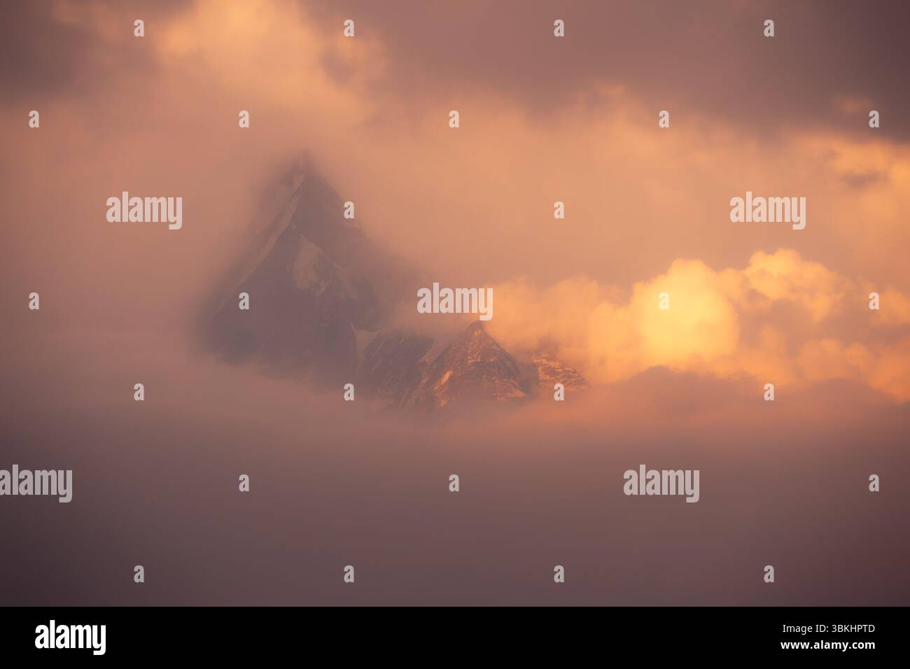 Ein atemberaubender Morgenblick auf Annapurna South, wenn der Gipfel im Sonnenlicht mit Wolken im großen Himalaya in Nepal schwimmt. Stockfoto