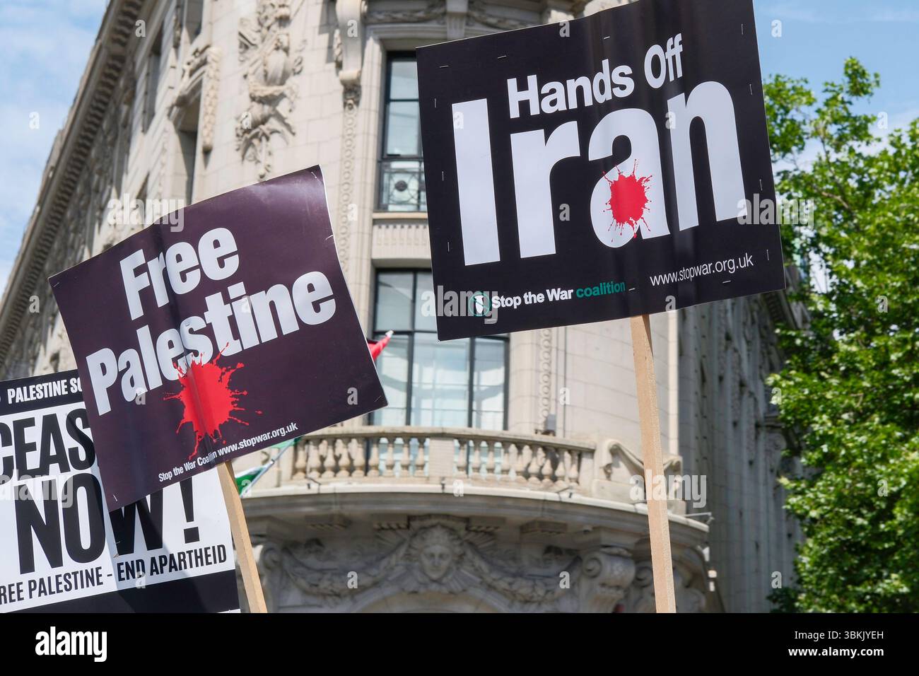 London, Großbritannien. Juni 2025. Tausende palästinensischer Solidaritätsdemonstratoren marschieren durch das Zentrum Londons, während ein statischer Gegenprotest, der von der pro-israelischen Gruppe Stop the Hate organisiert wird, in der Nähe der marschroute stattfindet. Im Bild: Plakate „Free Palestine“ und „Hands Off Iran“, die während des marsches im Zentrum Londons getragen wurden. Stockfoto