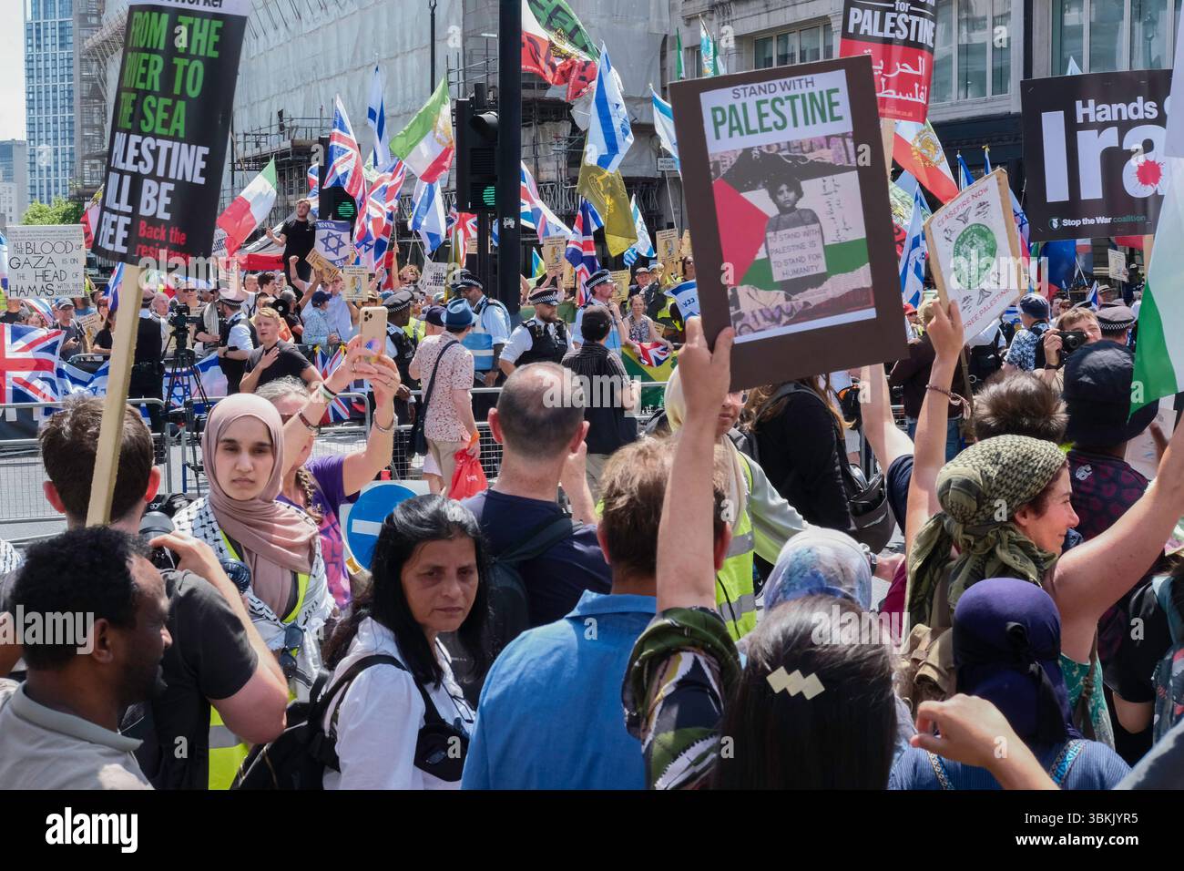 London, Großbritannien. Juni 2025. Tausende palästinensischer Solidaritätsdemonstratoren marschieren durch das Zentrum Londons, während ein statischer Gegenprotest, der von der pro-israelischen Gruppe Stop the Hate organisiert wird, in der Nähe der marschroute stattfindet. Im Bild: Palästinensischer solidaritätsmarsch vergeht in der Nähe des pro-israelischen Gegenprotests im Zentrum Londons. Stockfoto