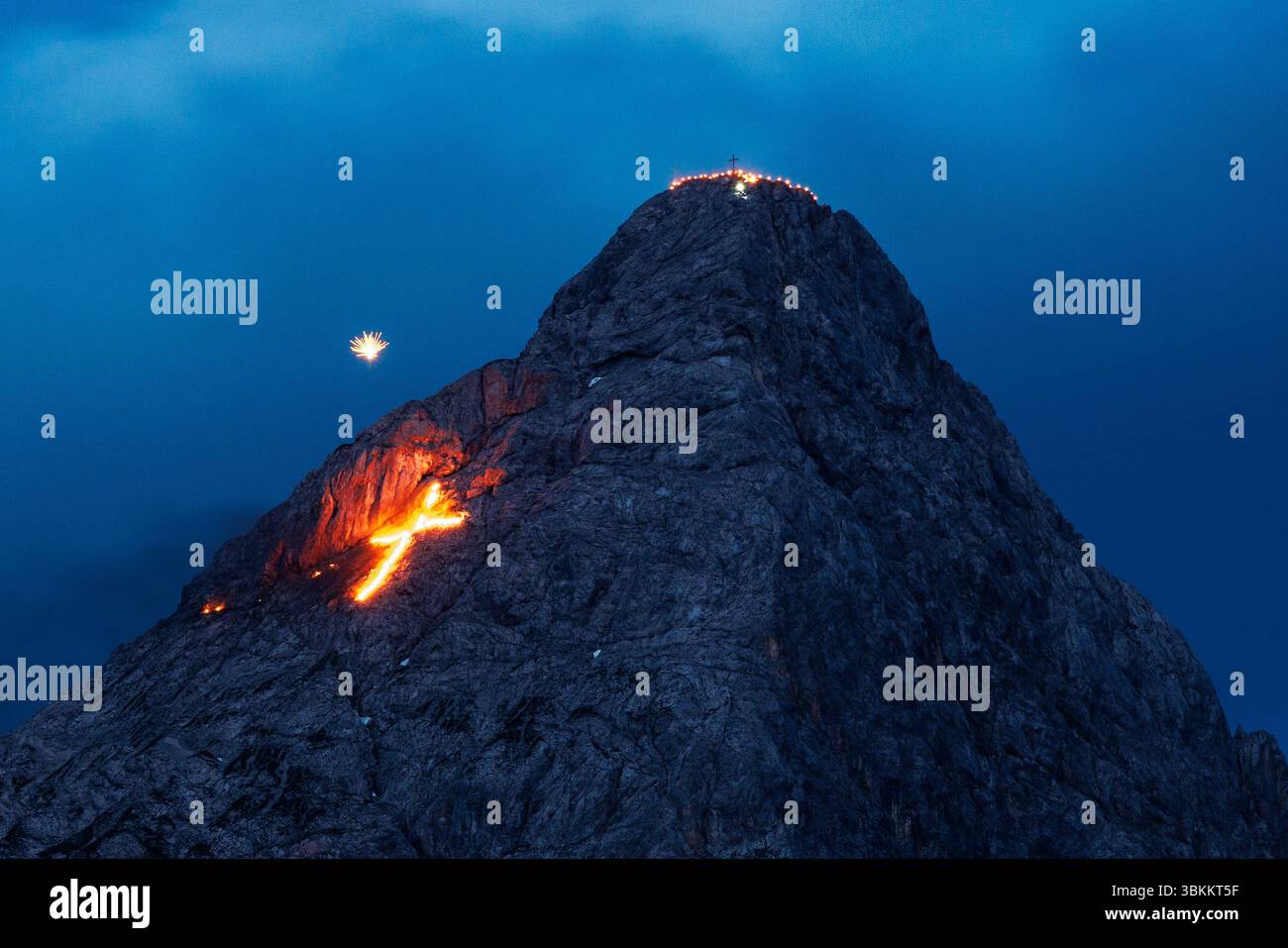 Lermoos, Österreich. 21. Juni 2025, Österreich, Lermoos: Zahlreiche Brände und ein explodierendes Feuerwerk sind auf den Bergen in der Tiroler Zugspitz Arena im Talbecken von Ehrwald Lermoos und Biberwier in Tirol (Österreich) am 21.06.2025 zur Sommersonnenwende zu sehen. Das Bild zeigt die Ehrwalder Sonnenspitze in der Mieminger Kette, auf der die Feuer ein Herz bilden, während am Himmel Feuerwerke zu sehen sind. Jedes Jahr wird der längste Tag und die kürzeste Nacht in der Region mit spektakulärem Feuerwerk gefeiert. Quelle: dpa Picture Alliance/Alamy Live News Stockfoto