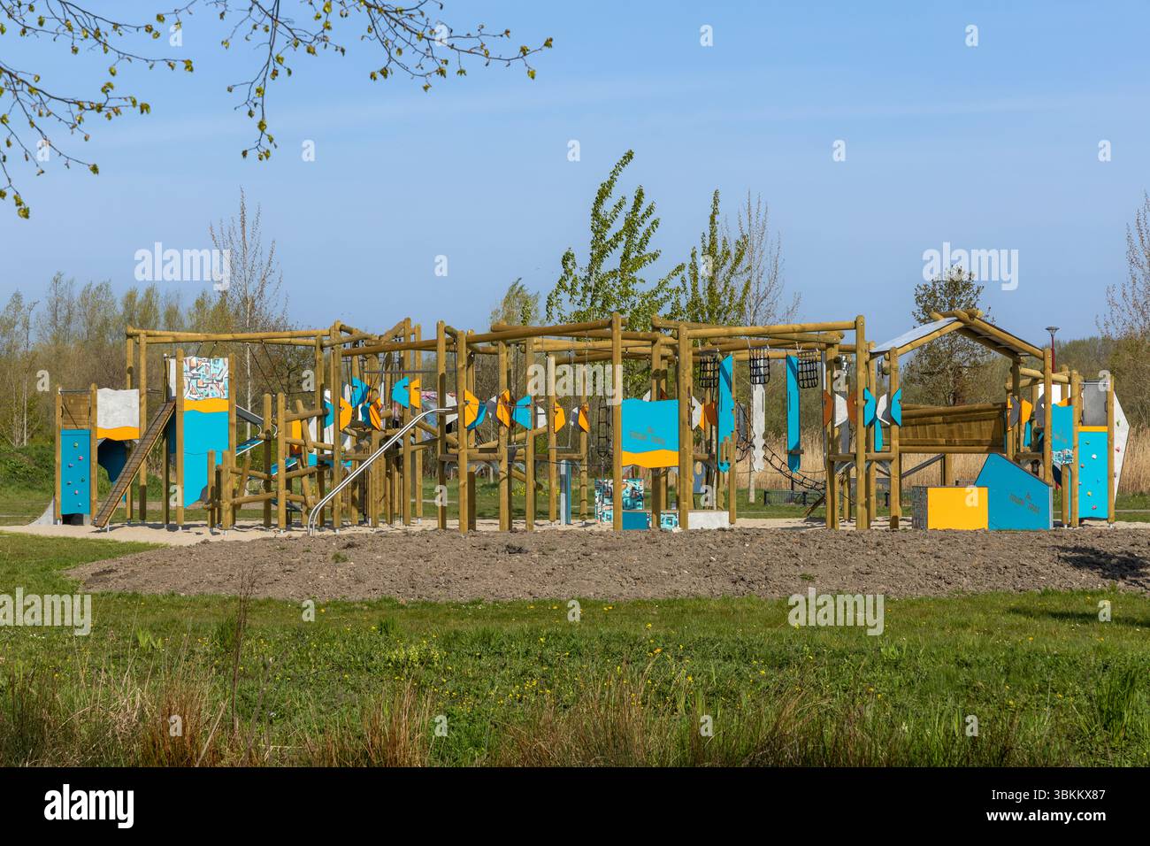 Farbenfroher hölzerner Abenteuerspielplatz in einem Park an einem sonnigen Tag. Perfekt für Outdoor-Aktivitäten und Freizeitaktivitäten für Kinder Stockfoto