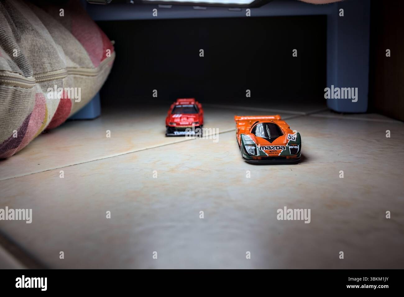 Mantova, Italien - 14. JUNI 2025 - Hot Wheels und Takara Tomi Replikate einer Mazda 787B und einer Nissan GTR Skyline Silhouette im Akt des Rennens im Inneren Stockfoto