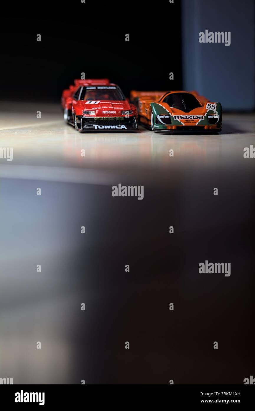 Mantova, Italien - 14. JUNI 2025 - Hot Wheels und Takara Tomi Replikate einer Mazda 787B und einer Nissan GTR Skyline Silhouette im Akt des Rennens im Inneren Stockfoto