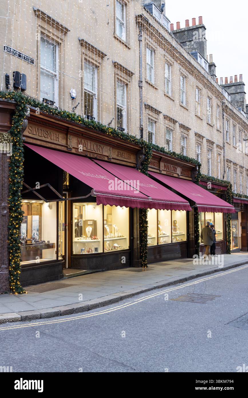 Mallory, der älteste Juwelier in Bath, beleuchtet mit Weihnachtslichtern in der Abenddämmerung. Bath Christmas Market, City of Bath, BANES, England, Großbritannien Stockfoto