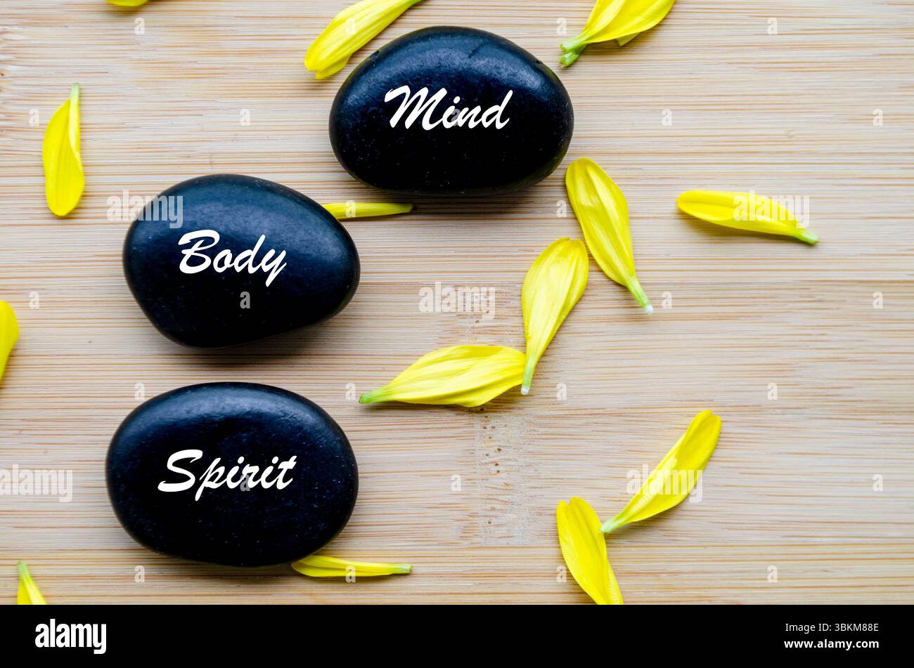 Zen-Steine beschrifteten Geist, Körper, Geist auf weißem Hintergrund und Blüten. Stockfoto