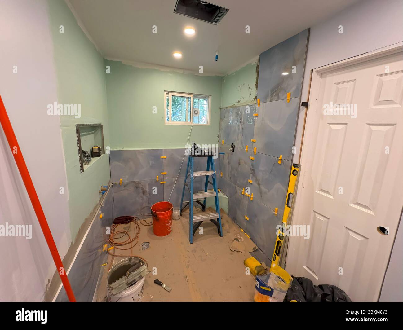 Im Rahmen eines Renovierungsprojekts werden geflieste Wände in einem Badezimmer installiert. Stockfoto