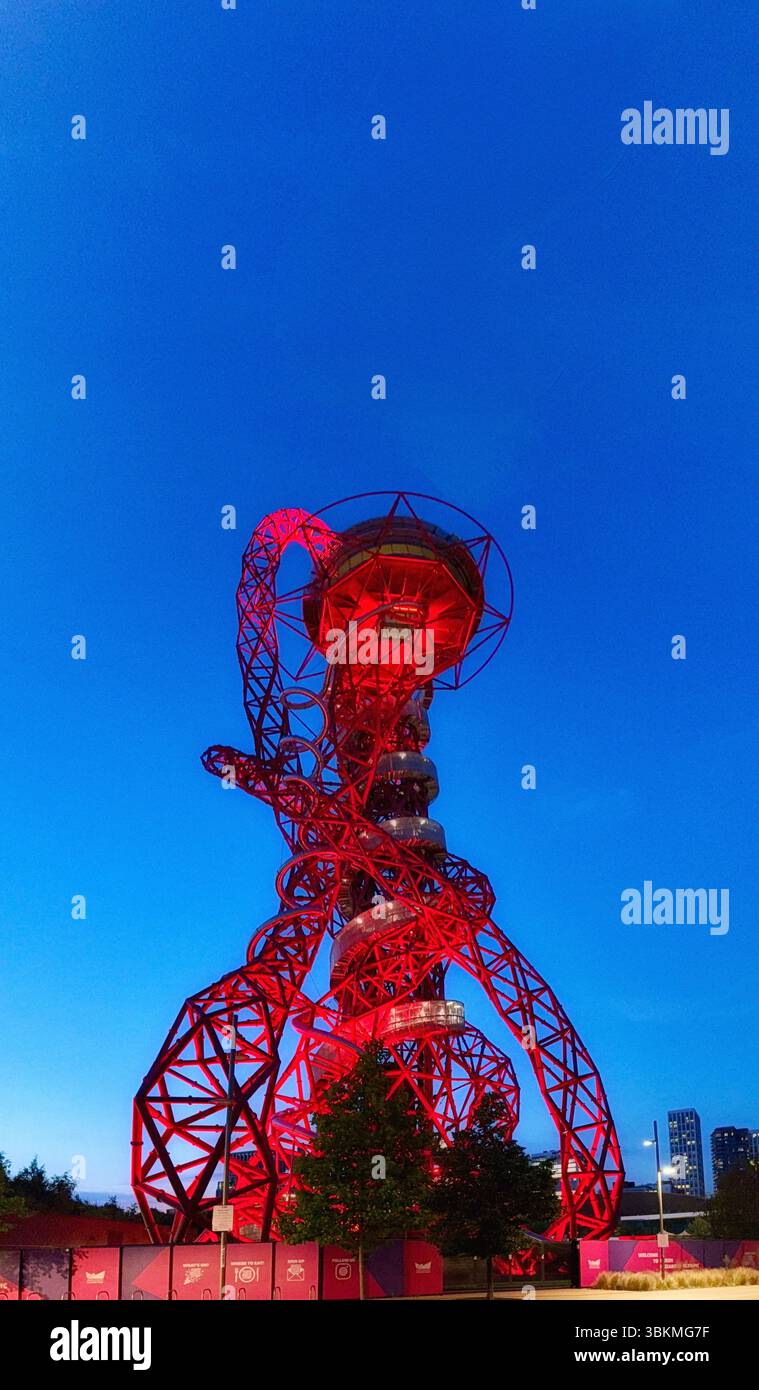 ArcelorMittal Orbit in der Abenddämmerung leuchtet rot im Olympic Park in Stratford, London. Entworfen von dem Bildhauer Sir Anish Kapoor und dem Ingenieur Cecil Balmond Stockfoto