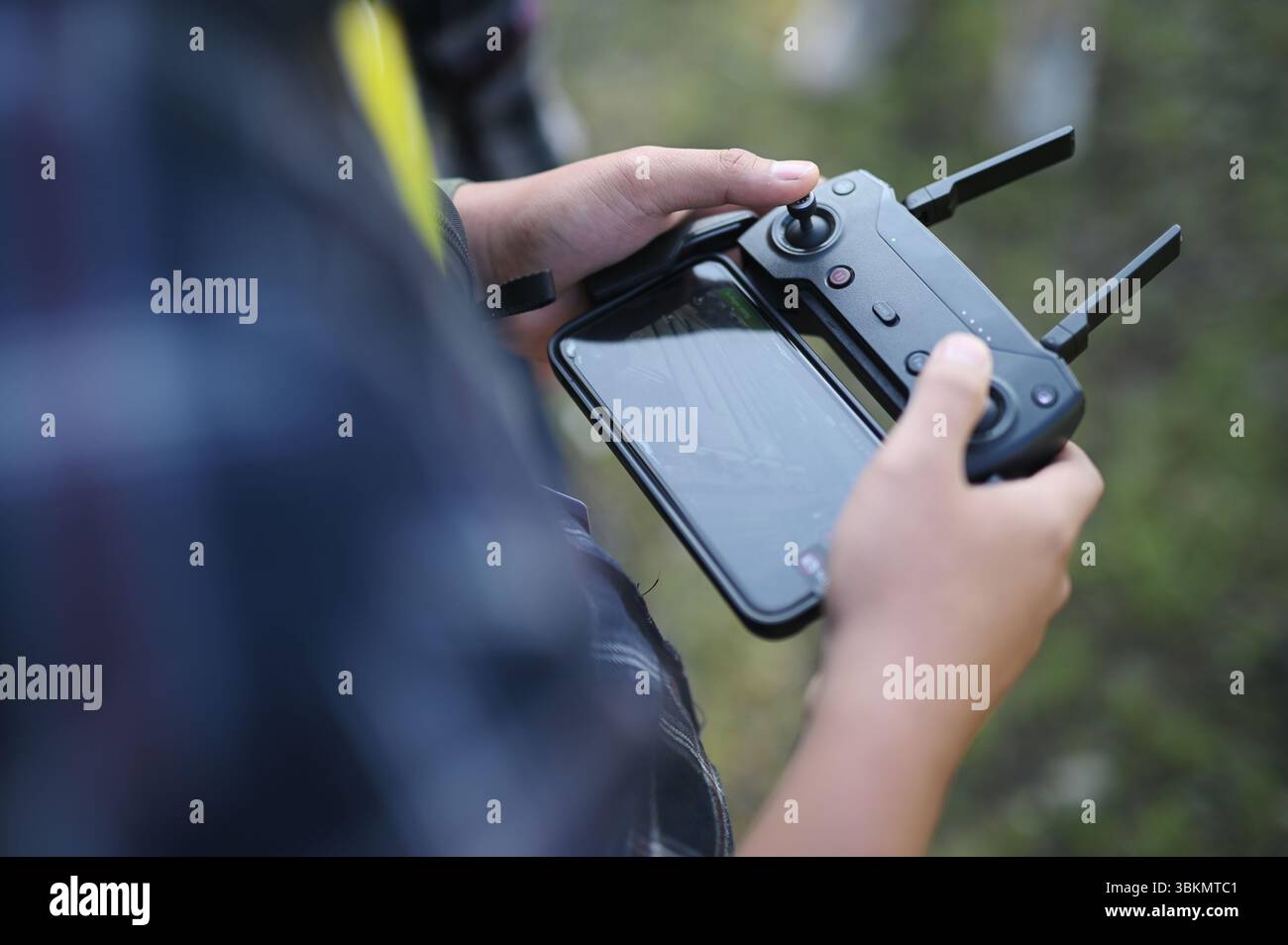 Der junge Mann hält seinen Drohnenkontrolleur fest Stockfoto