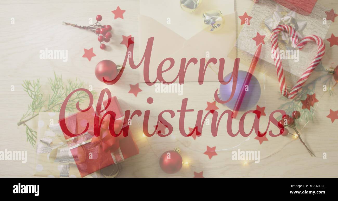 Mit rotem „Merry Christmas“-Schriftzug auf hellem Holztisch, Geschenkbox und Zuckerrohr Stockfoto