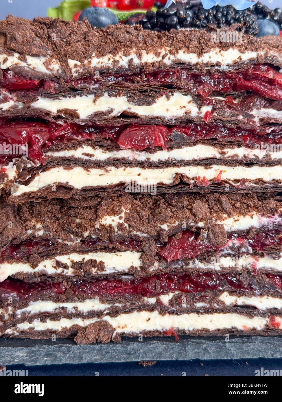 Schokoladige Schokoladenkuchenscheibe mit frischen Beeren und Krume-Topping Stockfoto