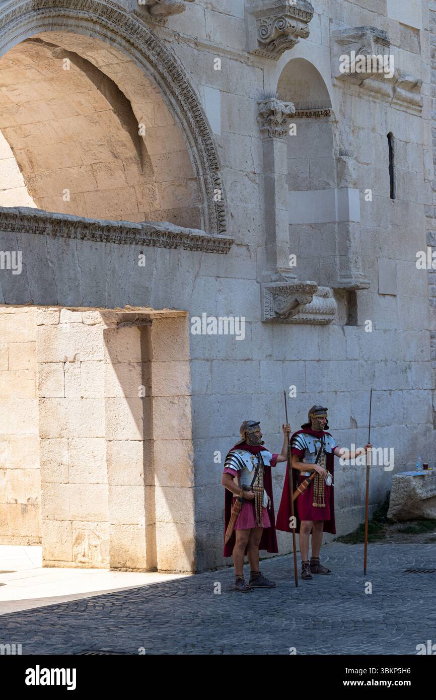 SPLIT, KROATIEN, 08.06.2018: Zwei römische Soldaten in historischer Kleidung, darunter Helme und Umhänge, die Speere halten, sind vor einem alten s stationiert Stockfoto