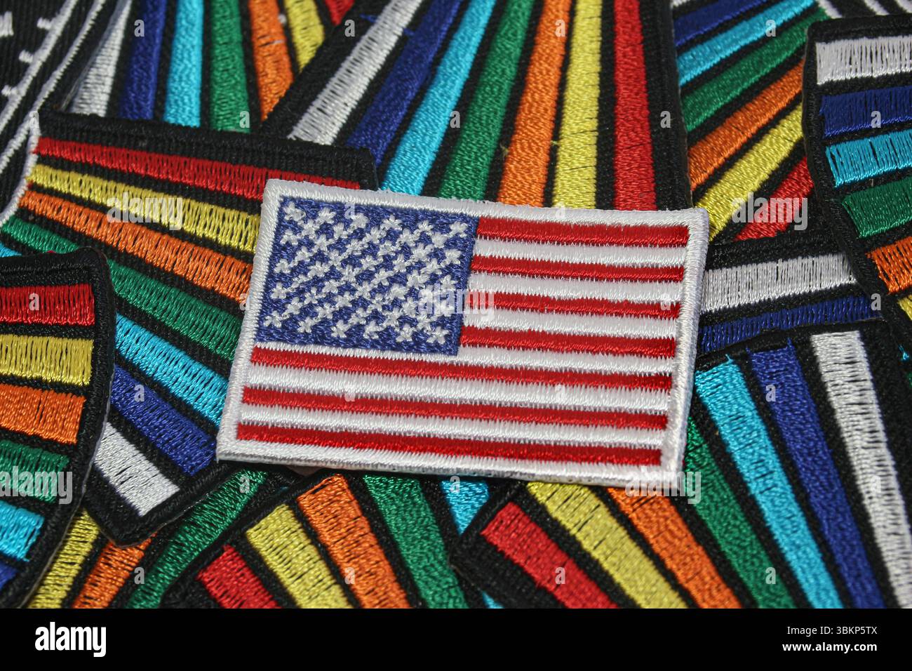 Handgemachte US-Flagge auf Regenbogenstoff-Hintergrund symbolisiert kulturelle Vielfalt und Inklusion in den Vereinigten Staaten von Amerika. Stockfoto