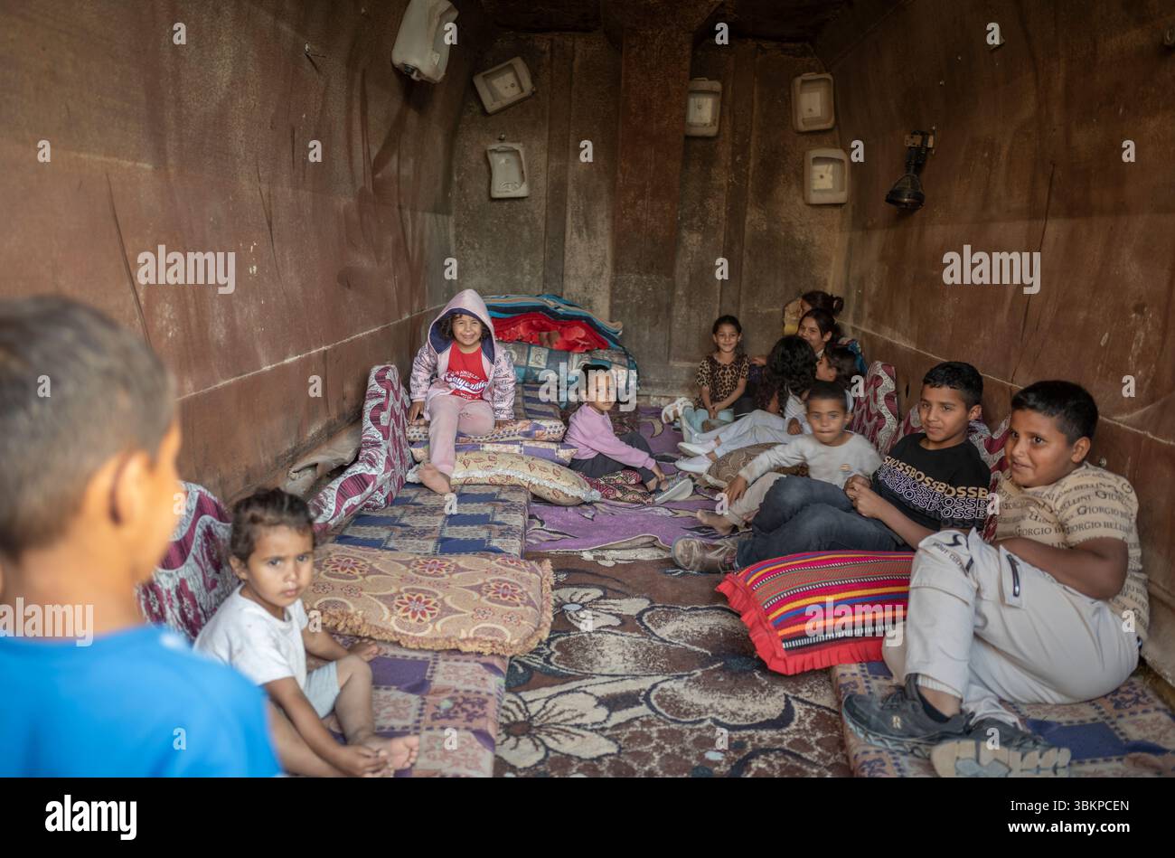 Al Furaa, Israel. Juni 2025. Die Kinder versammeln sich im provisorischen Bombenschutzraum, der aus in Schmutz vergrabenem Schotterwagen gebaut wurde, um sie vor eintreffenden iranischen Raketen im unbekannten Dorf Al-Furaa zu schützen. Die Negev-Beduinen sind traditionell pastorale nomadische arabische Stämme, die bis in die spätere Hälfte des 19. Jahrhunderts zwischen Hidschas im Osten und der Sinai-Halbinsel im Westen wandern. Heute leben die meisten in der Negev-Region in Israel. Quelle: Ilia Yefimovich/dpa/Alamy Live News Stockfoto