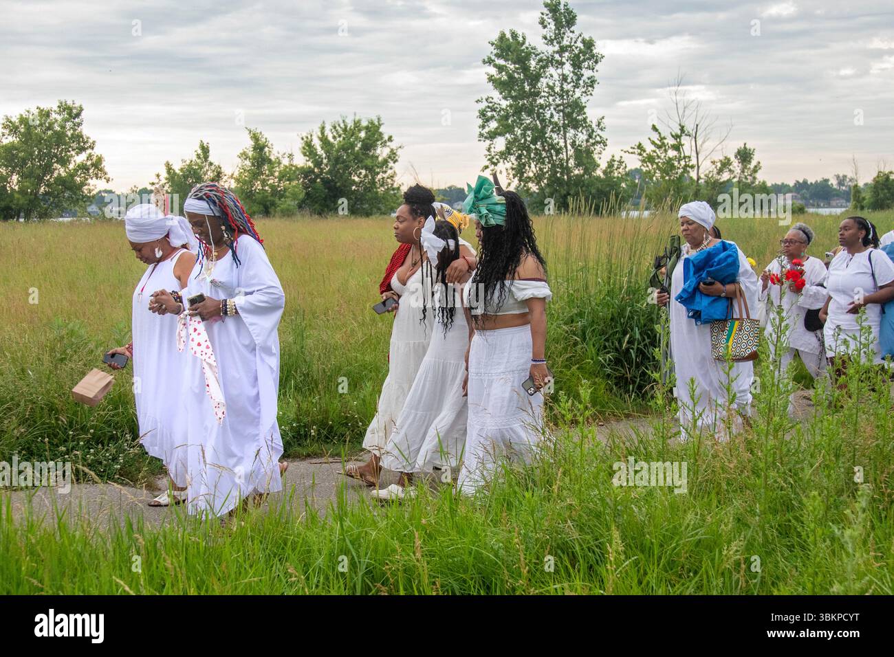 Detroit, Michigan, USA. Juni 2025. Afroamerikaner versammeln sich am Ufer des Detroit River, um an die im Sklavenhandel verlorenen Ahnen zu erinnern. Die jährliche Veranstaltung, bekannt als Karneval des Geistes, wird vom African Diaspora Ancestral Commemoration Institute organisiert. Quelle: Jim West/Alamy Live News Stockfoto
