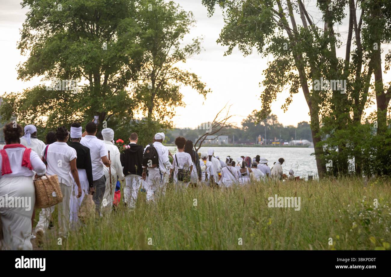 Detroit, Michigan, USA. Juni 2025. Afroamerikaner versammeln sich am Ufer des Detroit River, um an die im Sklavenhandel verlorenen Ahnen zu erinnern. Die jährliche Veranstaltung, bekannt als Karneval des Geistes, wird vom African Diaspora Ancestral Commemoration Institute organisiert. Quelle: Jim West/Alamy Live News Stockfoto