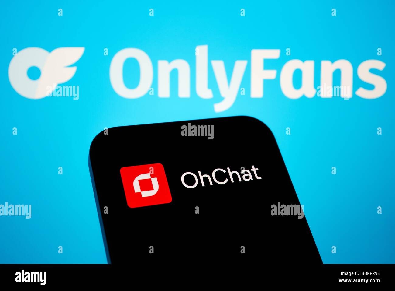 OhChat App-Logo auf dem Smartphone-Bildschirm mit verschwommenem OnlyFans-Logo im Hintergrund, das Plattformen für Erwachsene und Tools zur Monetarisierung in sozialen Netzwerken hervorhebt. Staffor Stockfoto