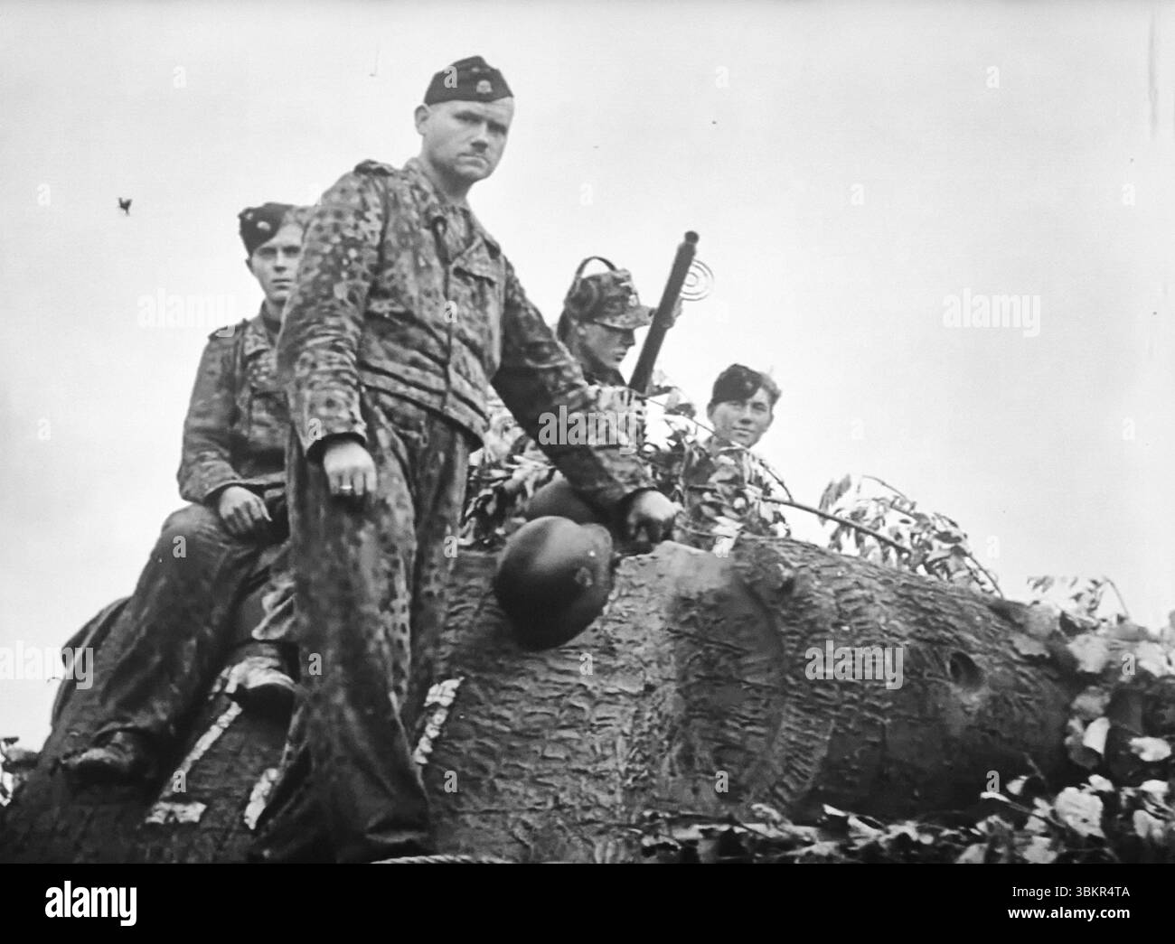 WW2 Screen B&W immer noch deutsche Besatzungsmitglieder eines Panther-Panzers in Pea Dot Camo Ride an Bord ihres Panzers Stockfoto