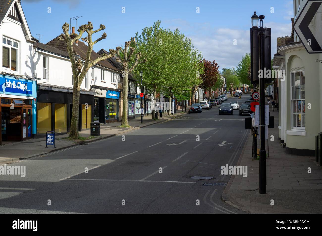 Ein sonniger Tag auf der High Street in Saffron Walden, Essex, mit Geschäften und Bäumen entlang der Straße Stockfoto