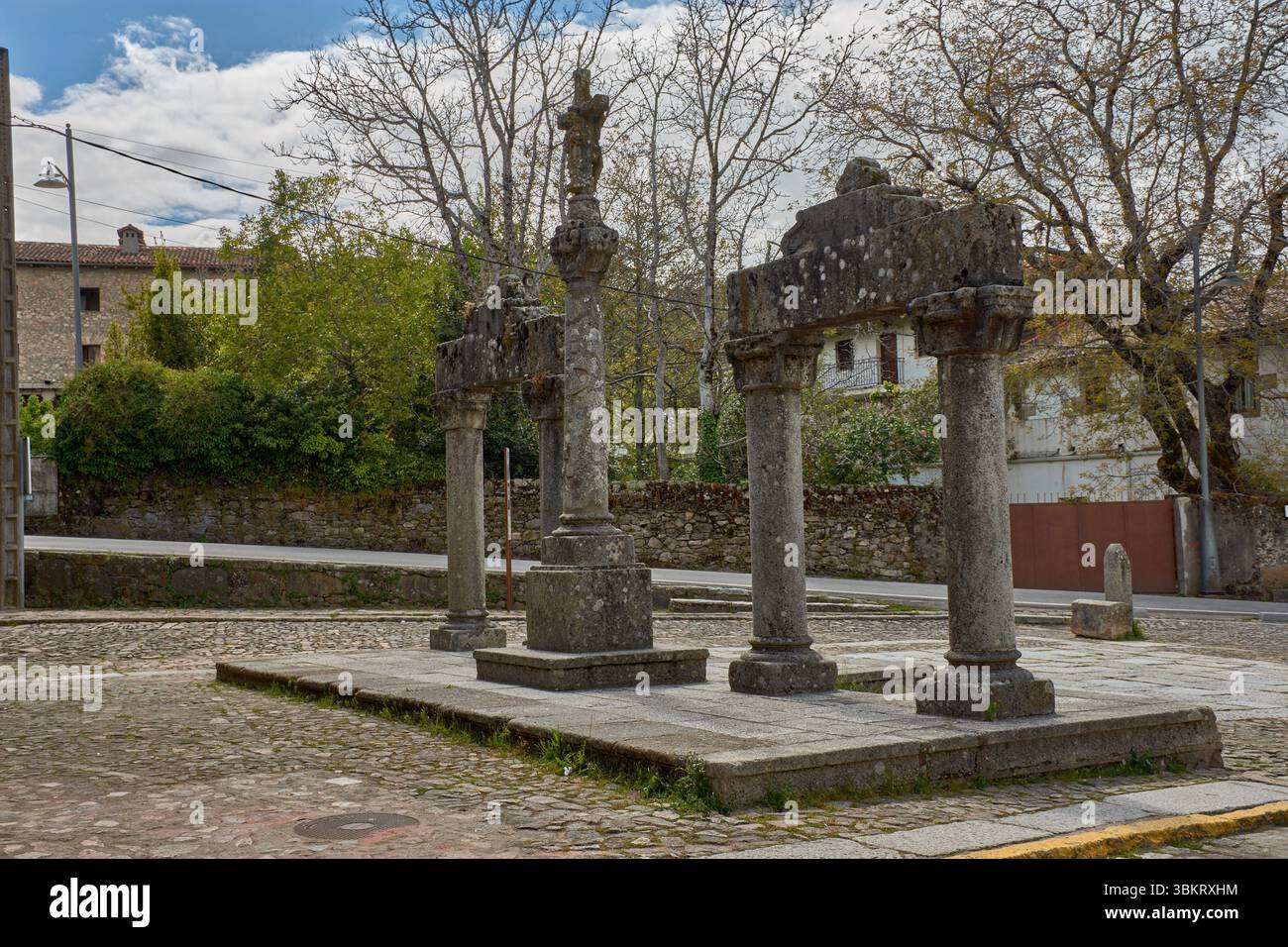 Gepflasterte Gasse in La Alberca, flankiert von traditionellen Stein- und Fachwerkhäusern, mit Balkonen und Fenstern, die mit Töpfen und Blumen dekoriert sind. Stockfoto