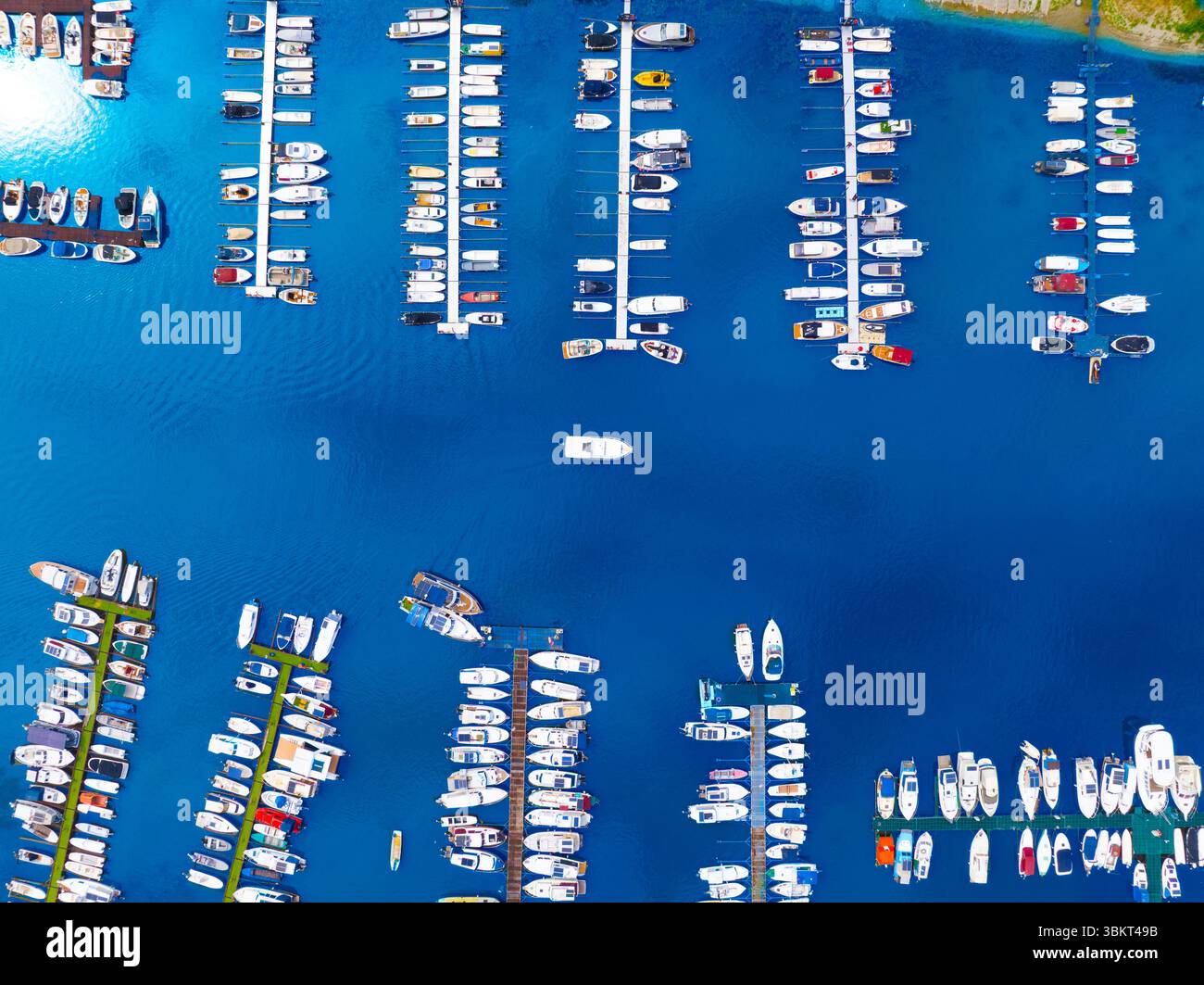 Top-Down-Reisefoto eines Schiffes, das in einen Hafen navigiert. Stockfoto