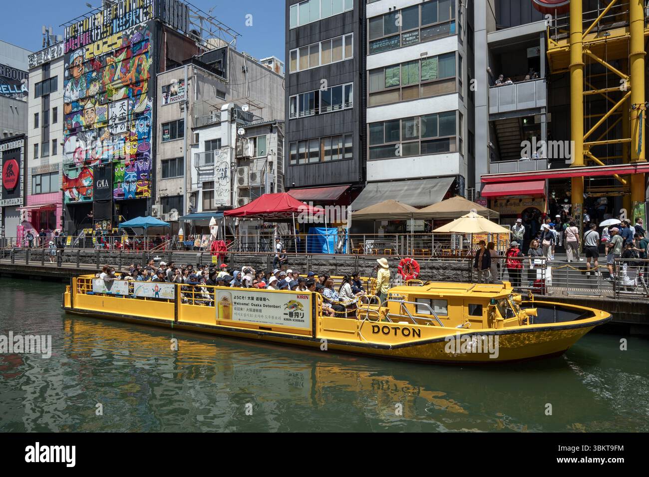 Touristenboot in der Nähe der Ebisu-Brücke auf dem Dotonbori-Kanal im Namba-Viertel von Osaka, Japan. Stockfoto