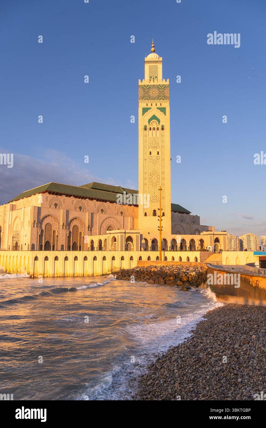 Casablanca, Marokko: Sonnenuntergang über der berühmten Moschee Hassan II und dem Minarett am Atlantik in Casablanca, der größten Stadt Marokkos. Stockfoto