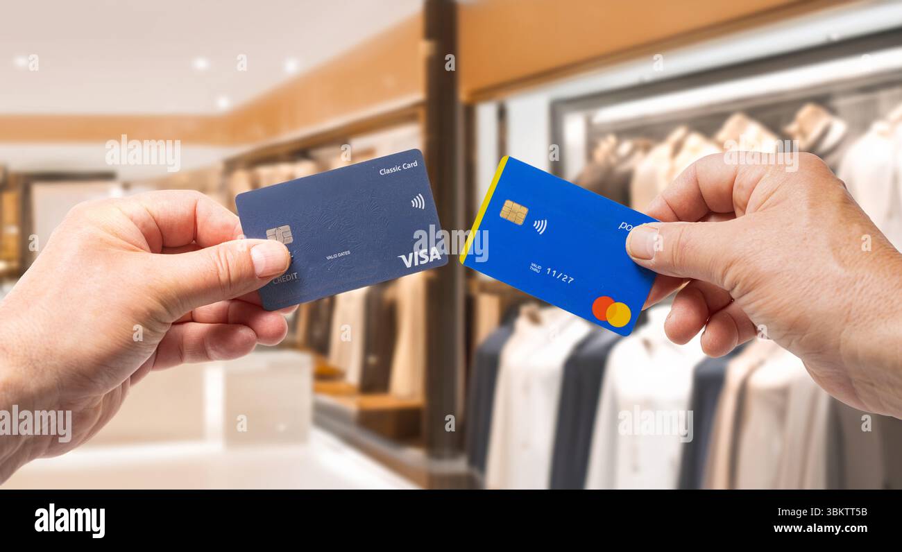 Italien, 22. juni 2025. Kreditkarten der Marken Mastercard und VISA mit einem Luxusgeschäft im Hintergrund Stockfoto