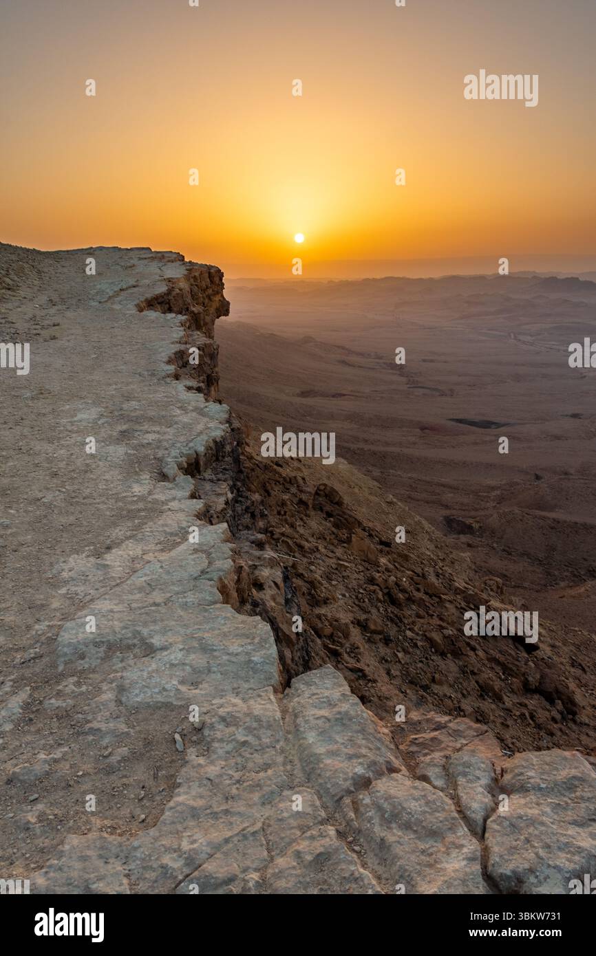 Die Sonne steigt über den Klippen des Ramon-Kraters (Makhtesh Ramon) in der Wüste Negev im Süden Israels auf Stockfoto