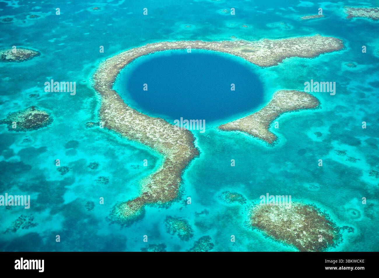 Aus der Vogelperspektive auf das Korallenriff und die tiefe Höhle, die den berühmten Tauchplatz des Blue Hole im Karibischen Ozean vor der Küste von Belize bilden. Stockfoto