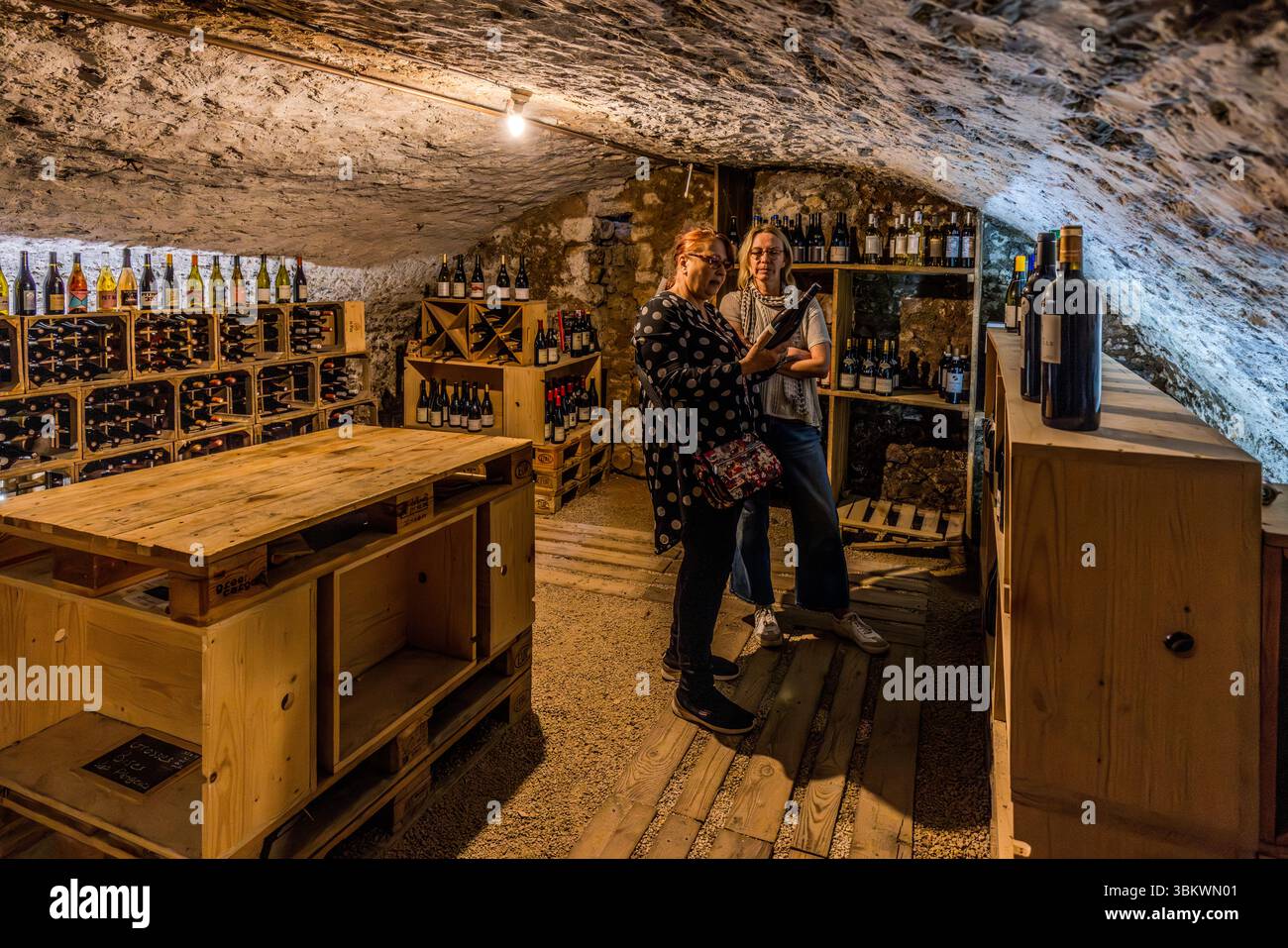 Weinkeller mit Selbstbedienung im Auberge Restaurant Chez cUL de Paille in Poitiers. Gäste gehen in den Kellerraum und wählen eine Flasche Wein für ihre Mahlzeit. Die Preise sind auf den Weinboxen angegeben. Die Gäste nehmen die Flasche selbst an ihren Tisch, wo sie vom Personal geöffnet wird. Eine der Besonderheiten der Auberge Le cUL de Paille ist, dass Gäste ihren eigenen Tafelwein im Keller wählen können und dass viele berühmte Künstler, wie Jaques Brel, sich an den Wänden mit Autogrammen, Sprüchen und Zeichnungen verewigt haben. Rue Théophraste Renaudot, Poitiers, Nouvelle-Aquitaine, Fra Stockfoto