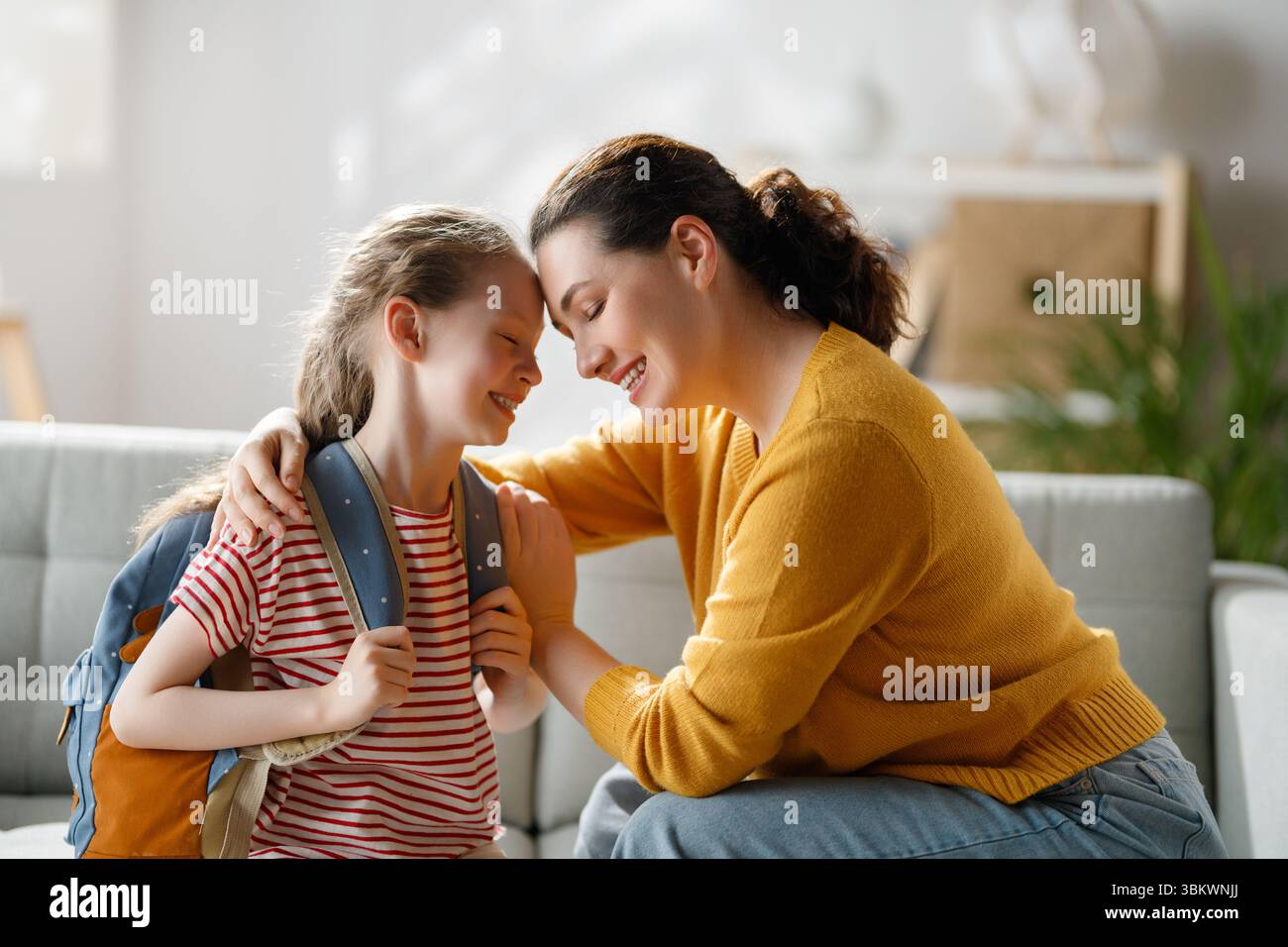 Glückliche Familie bereitet sich auf die Schule vor. Kleines Mädchen mit Mutter. Stockfoto